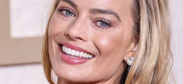 Margot Robbie A '10/10′ en bikini tanga con champán junto a la piscina
